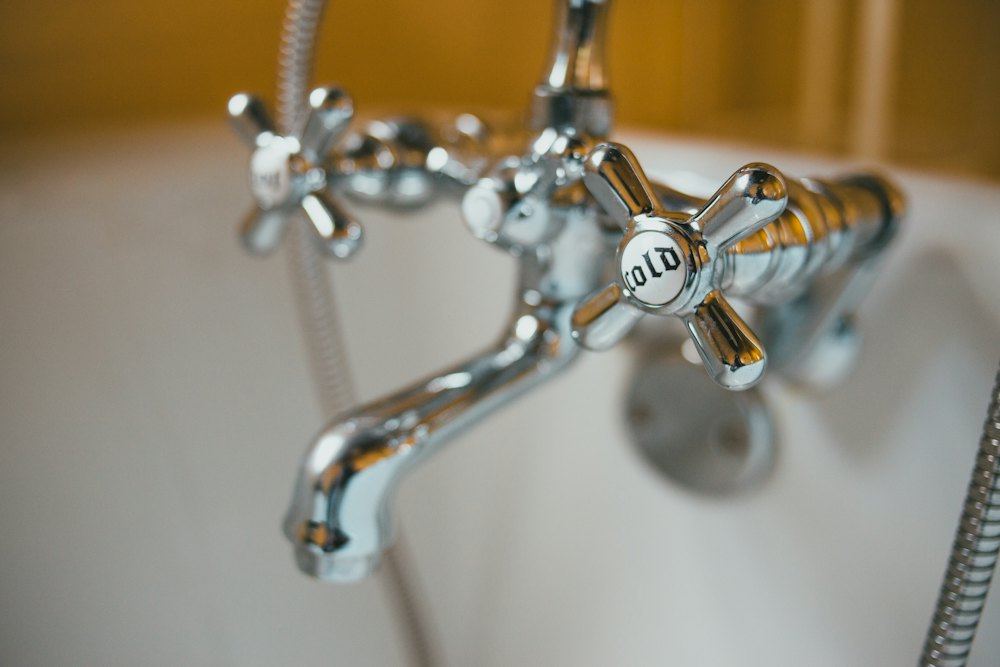 A chrome faucet with water droplets