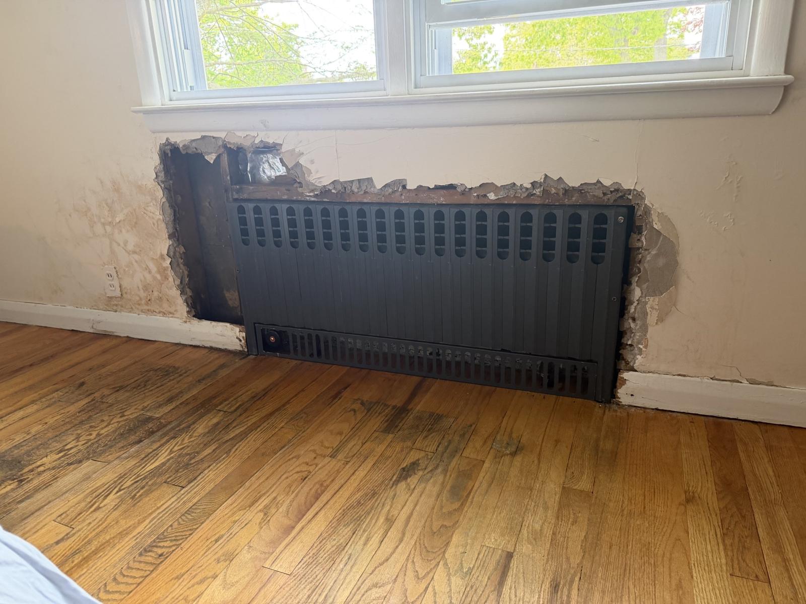 A new radiator installed in the wall recess left by the old one