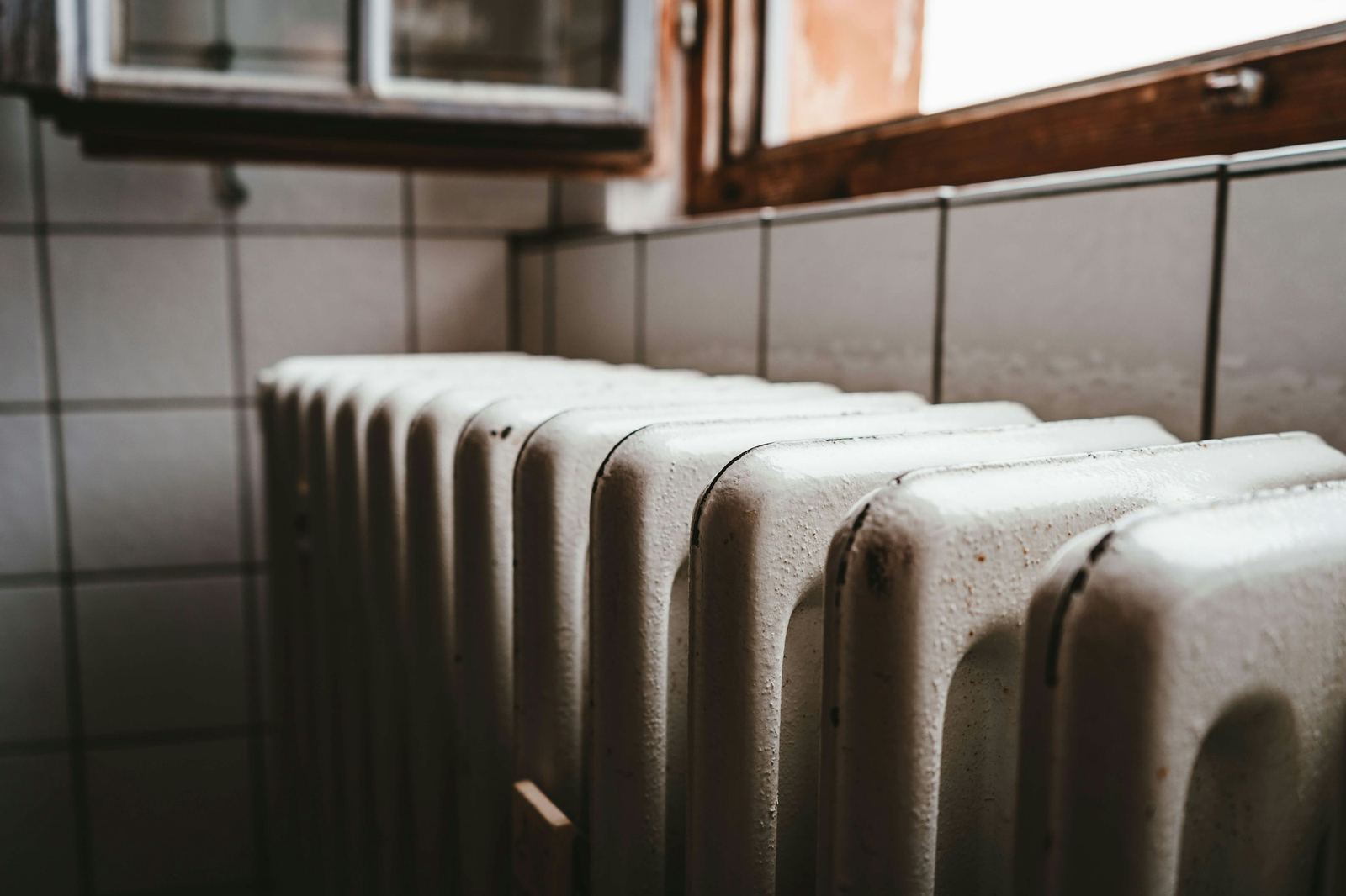 A radiator being installed on a wall, part of the heating system a boiler repair in Westchester puts back to work