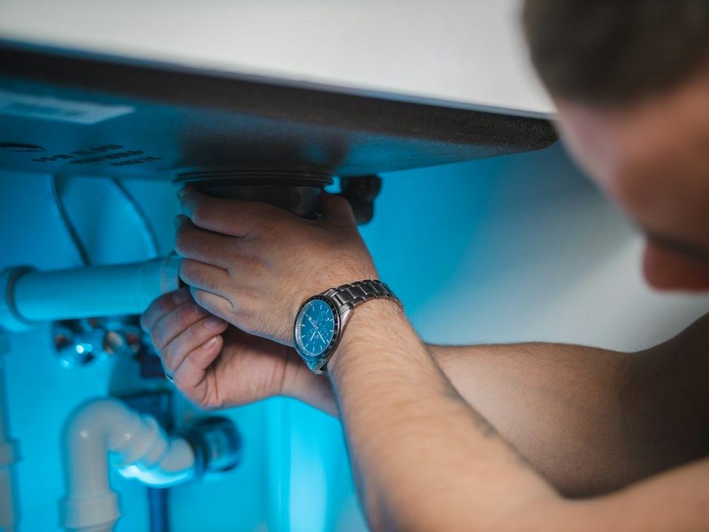 A technician servicing a domestic water heater