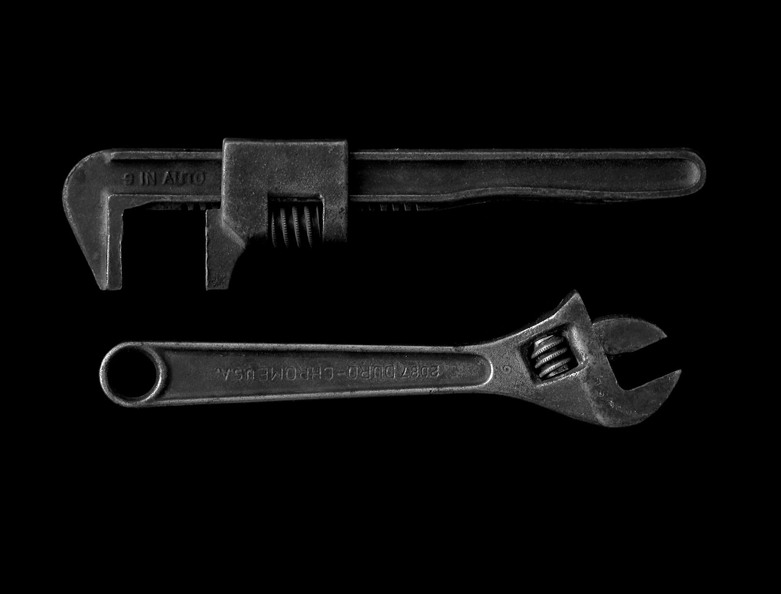 A pipe wrench and adjustable wrench ready for a plumbing maintenance visit