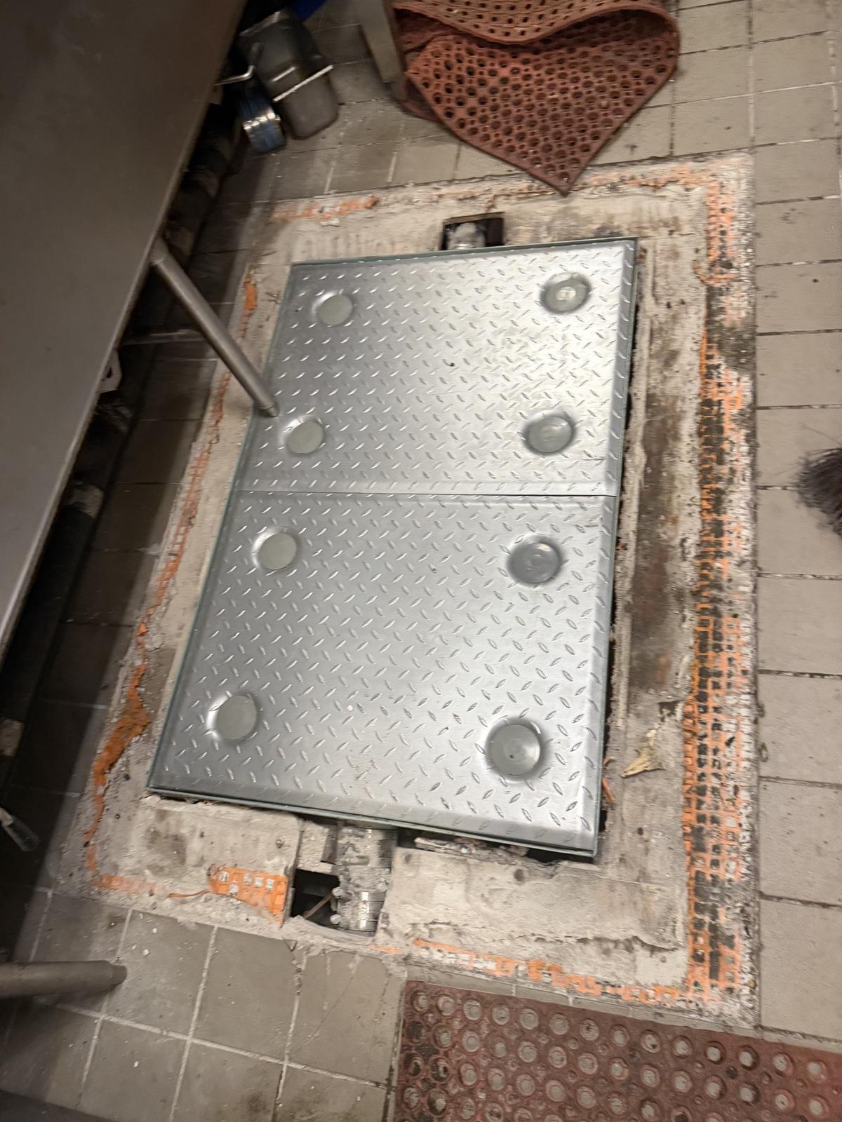 The finished commercial kitchen floor hatch, diamond plate and flush with the tile